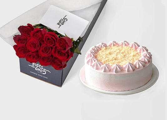 Red roses in a gift box beside a decorated cake, showcasing a thoughtful cake and flower delivery in Singapore for celebrations.