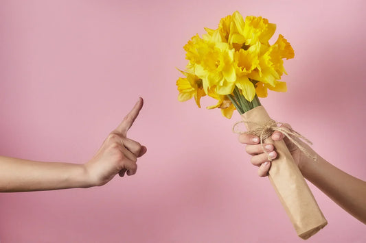 Hand rejecting a bouquet of yellow flowers, highlighting warning signs to check before you order flowers online in Singapore.